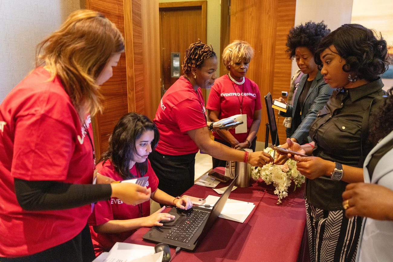 EventPro Connect team members in red shirts checking in guests at the registration table
