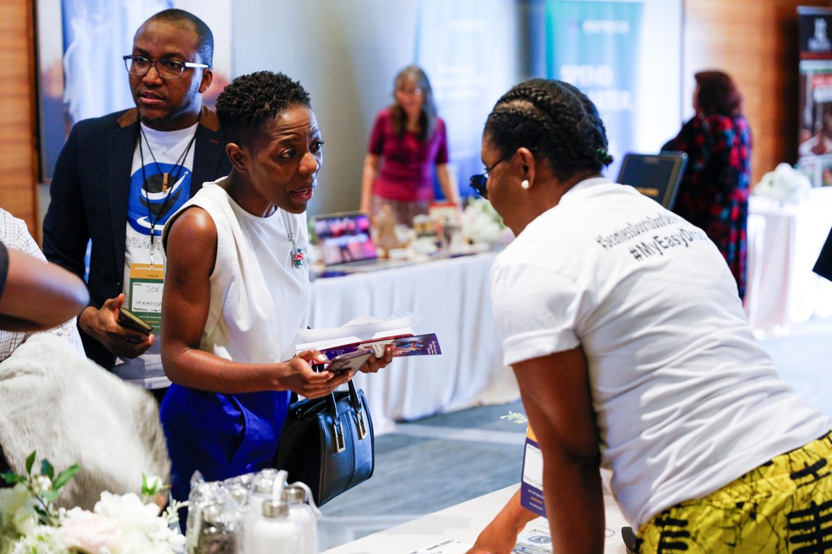 An attendee talking with a vendor at their table at EventPro Connect 2.0